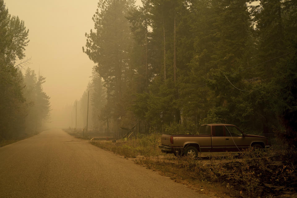 Downed power lines lie on a pickup truck in an area burned by the Lower East Adams Lake wildfire, in Scotch Creek, British Columbia, on Sunday, Aug. 20, 2023. (Darryl Dyck/The Canadian Press via AP)