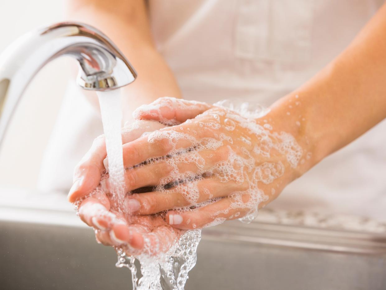 A person washes their hands with soap