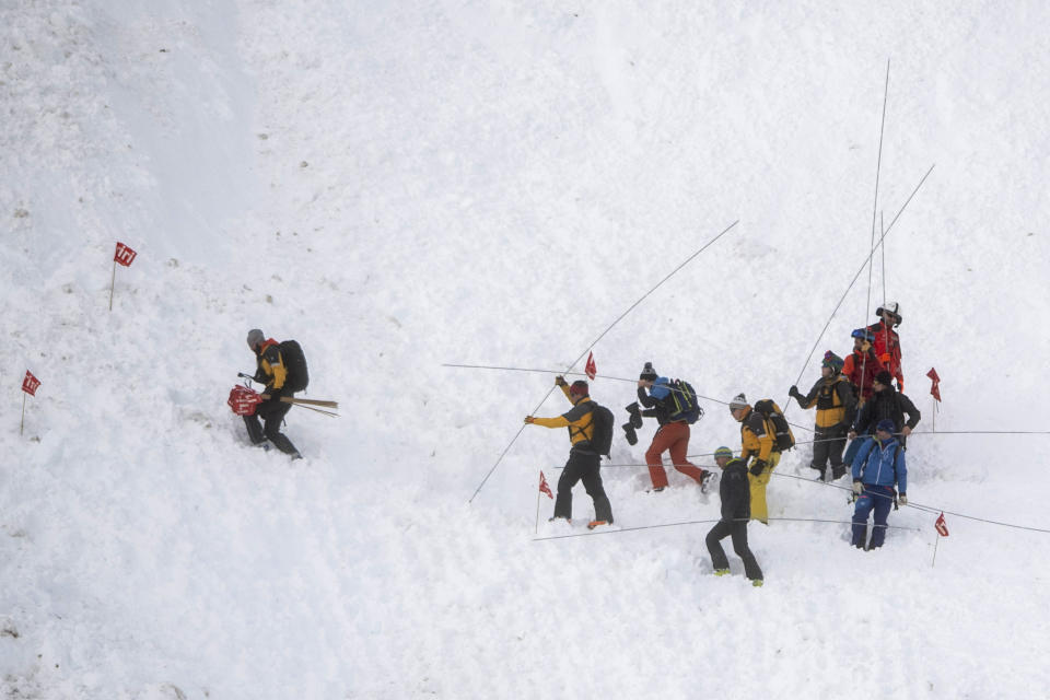 Rescue forces search for missing people after an avalanche swept down a ski piste in the central town of Andermatt, canton Uri, Switzerland, Thursday, Dec. 26, 2019. The avalanche occurred mid-morning Thursday while many holiday skiers enjoyed mountain sunshine the day after Christmas. (Urs Flueeler/Keystone via AP)