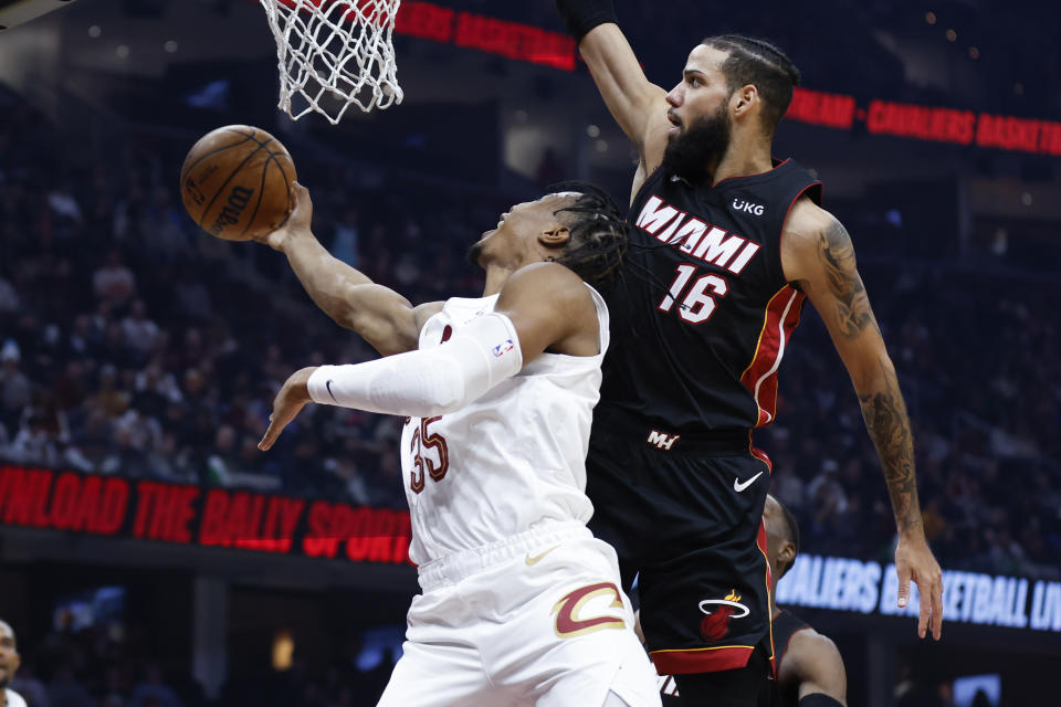 Cleveland Cavaliers forward Isaac Okoro (35) shoots against Miami Heat forward Caleb Martin (16) during the first half of an NBA basketball game, Sunday, Nov. 20, 2022, in Cleveland. (AP Photo/Ron Schwane)