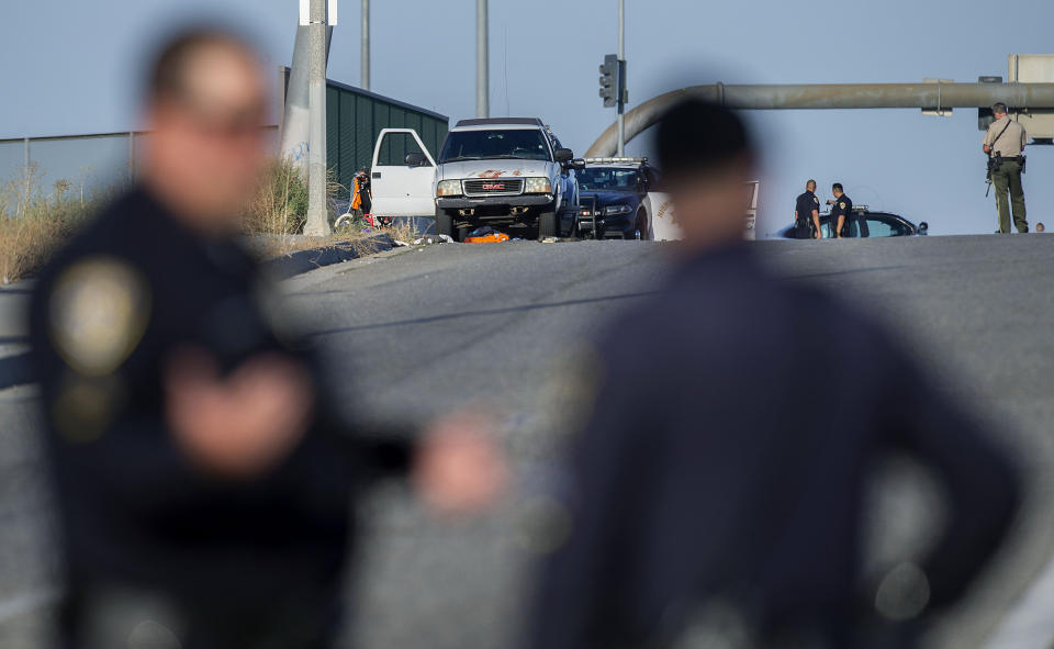 Authorities work the scene where a shootout near a freeway killed a California Highway Patrol officer and wounded two others before the gunman was fatally shot, Monday, Aug. 12, 2019, in Riverside, Calif. (Terry Pierson/The Orange County Register via AP)