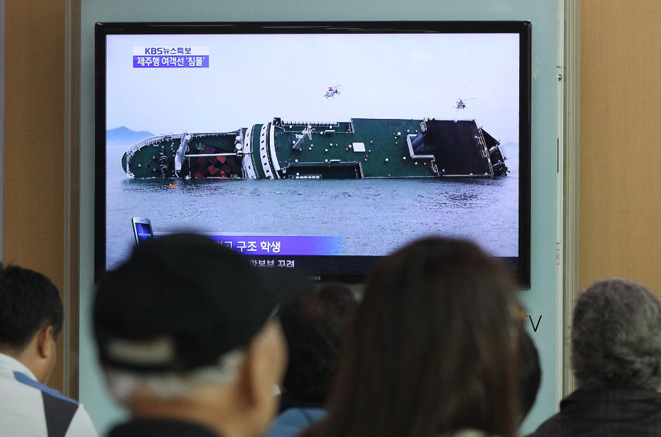 People watch a TV news program showing a sinking passenger ship, at Seoul Railway Station in Seoul, South Korea, Wednesday, April 16, 2014. The South Korean passenger ship carrying more than 470 people, including many high school students, is sinking off the country's southern coast Wednesday after sending a distress call, officials said. There are no immediate reports of causalities.(AP Photo/Ahn Young-joon)