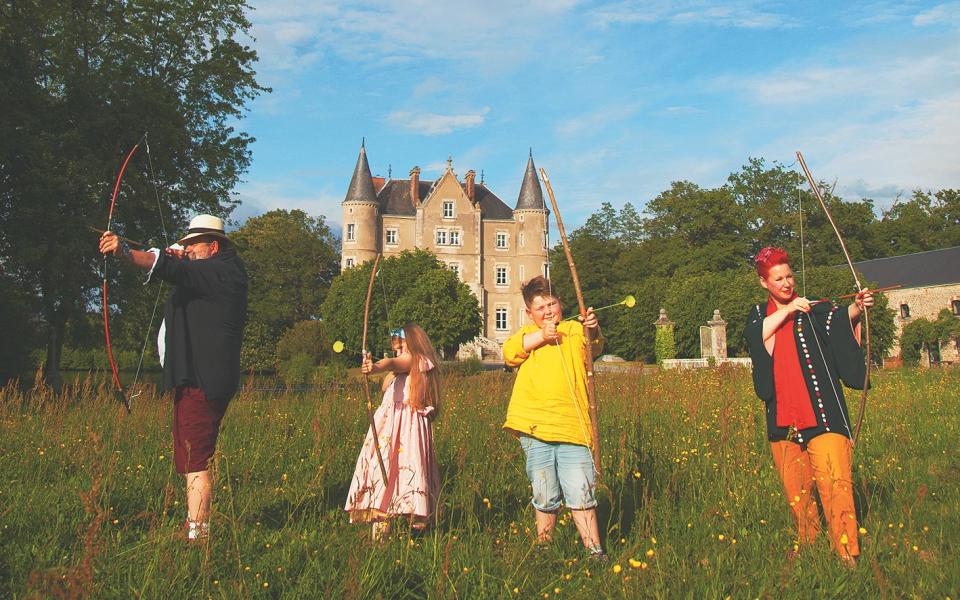 Bow and arrow fun with their children, Dorothy, seven, and Arthur, eight - Miles Carter