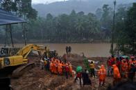 Rescue workers carry the body of a victim after recovering it from the debris of a residential house following a landslide in Kokkayar