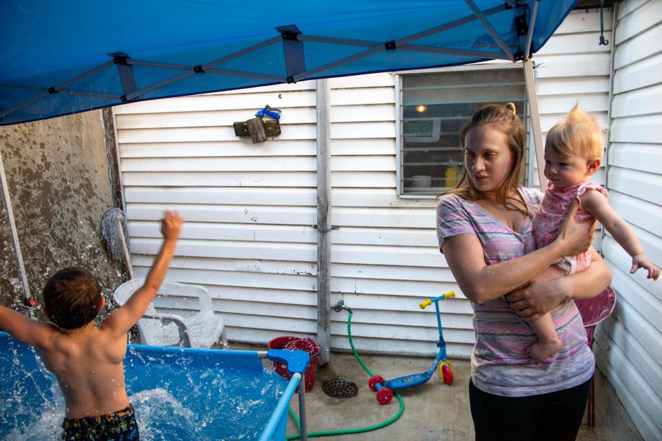 Carmen Aponte-Vincent, 22, holds her daughter Maria Floyd as her son Chase Aponte-Hopely, 6, plays in the pool at home in Philadelphia, Pa. on Friday, June 4, 2021.