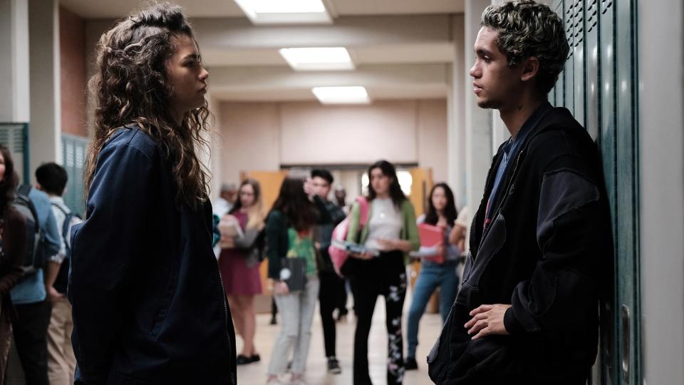Zendaya and Dominic Fike stand in a school hallway in Euphoria season 2