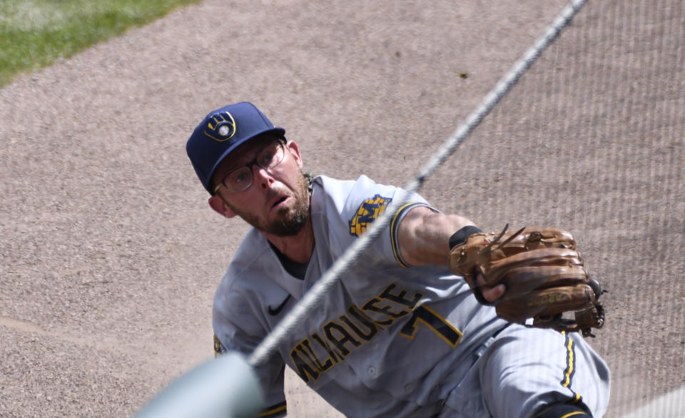 Milwaukee Brewers third baseman Eric Sogard tries to catch a foul ball hit by Chicago Cubs designated hitter Victor Caratini during the fourth inning of a baseball game Sunday, July, 26, 2020, in Chicago. (AP Photo/David Banks)