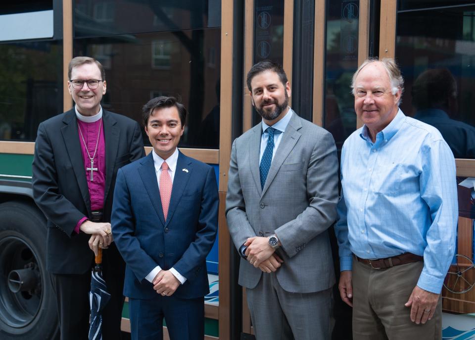 Bishop W. Nicholas Knisely of the Episcopal Diocese of Rhode Island; Newport Mayor Xay Khamsyvoravong; Christopher Durand, RIPTA interim chief executive officer; and Evan Smith, president and CEO of Discover Newport, stand in front of a RIPTA trolley.