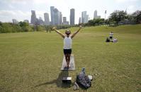 Trey Evans participates in an online yoga class using his laptop and headphones outside at Eleanor Tinsley Park near downtown Houston, Tuesday, March 24, 2020. BIG Power Yoga has been holding online classes during the coronavirus outbreak. A Stay Home - Work Safe Order was issued Tuesday for Houston and Harris County residents to help fight the spread of COVID-19. The order will go into effect at 11:59 p.m. and will last until April 3. Harris County Judge Lina Hidalgo said people should stay home except for essential needs. (AP Photo/David J. Phillip)