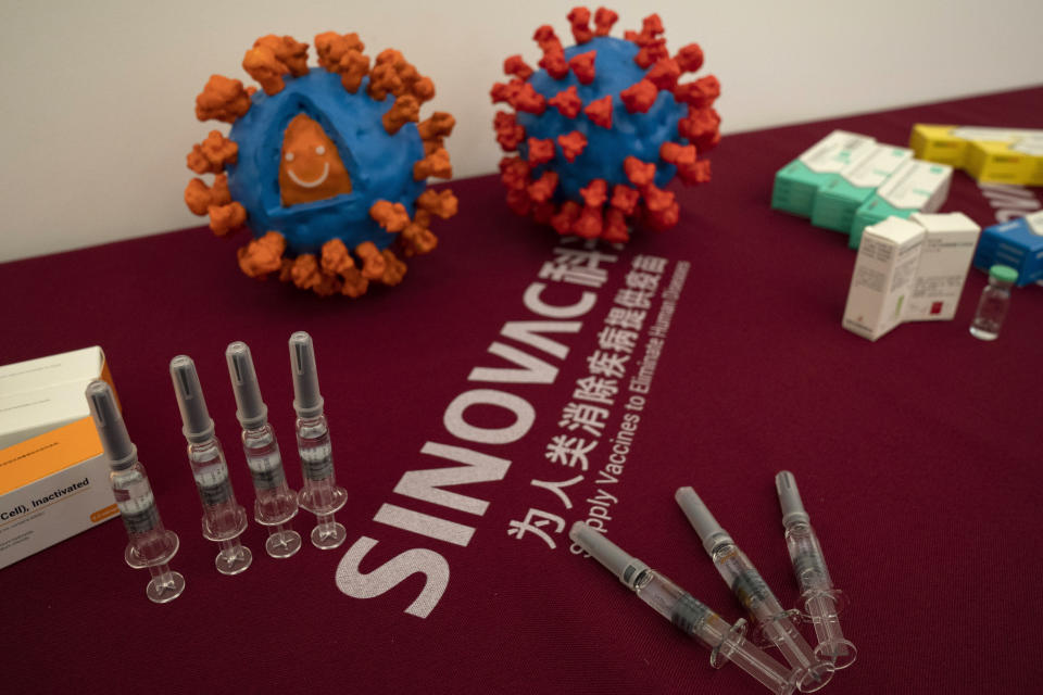 Syringes of a vaccine for COVID-19 and models depicting the coronavirus are displayed at the Sinovac factory in Beijing on Thursday, Sept. 24, 2020. With rich countries snapping up supplies of COVID-19 vaccines, some parts of the world may have to rely on Chinese-developed shots to conquer the outbreak. The question: Will they work? (AP Photo/Ng Han Guan)