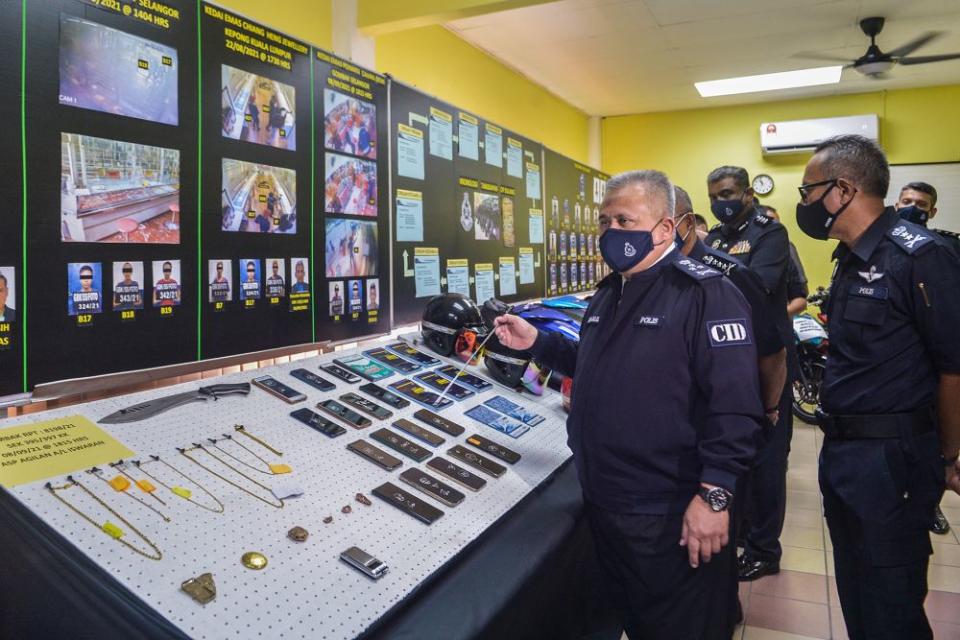 Criminal Investigation Department director Datuk Seri Abd Jalil Hassan goes through items seized from the Geng Amir @ Kecik during a press conference at the Gombak district police headquarters September 24, 2021. — Picture by Miera Zulyana