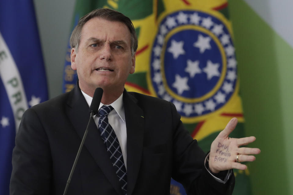 Brazil's President Jair Bolsonaro's hand shows notes for his speech that read in Portuguese "God, Family, Brazil," during the launching ceremony of the Doctors for Brazil Program, at the Planalto Presidential Palace, in Brasilia, Brazil, Thursday, Aug. 1, 2019. According to the government, the Doctors for Brazil Program will replace the program implemented by Former President Dilma Rousseff with the help of Cuban doctors, replacing them with Brazilian doctors. (AP Photo/Eraldo Peres)