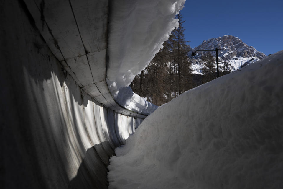 FILE - The bobsled track in Cortina d'Ampezzo, Italy, is shown on Feb. 17, 2021. Costly construction delays, a leadership vacancy linked to a volatile political climate and a lack of sponsors amid a spreading financial crisis has prompted International Olympic Committee president Thomas Bach to acknowledge the "challenges" facing organizers for the 2026 Winter Games in Milan and Cortina d'Ampezzo. (AP Photo/Gabriele Facciotti, File)