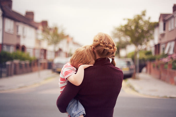 backside of a woman holding her child