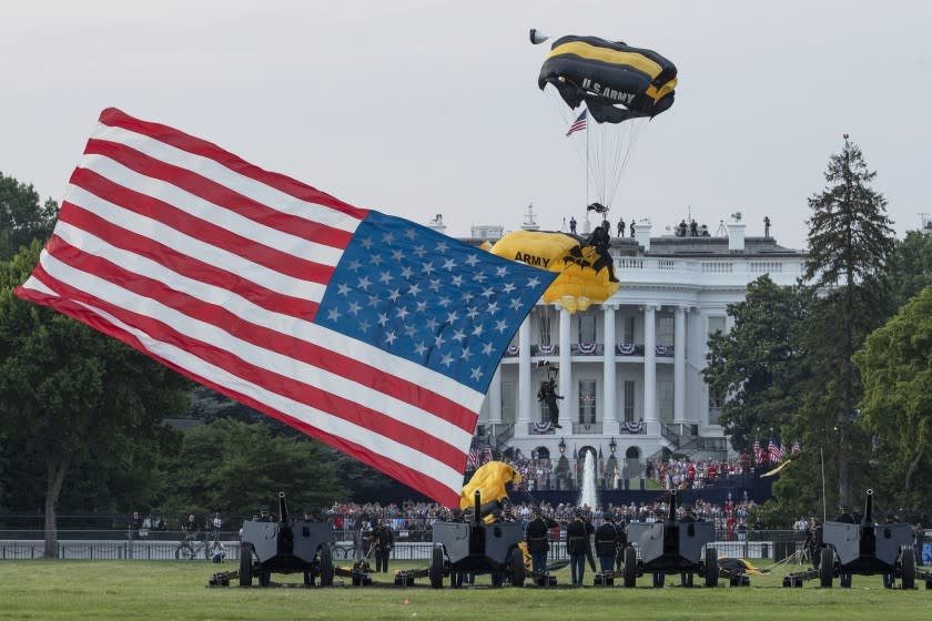 President Donald Trump and first lady Melania Trump watch as the U.S. Army Golden Knights Parachute Team descend during a "Salute to America" event on the South Lawn of the White House, Saturday, July 4, 2020, in Washington. (AP Photo/Alex Brandon)