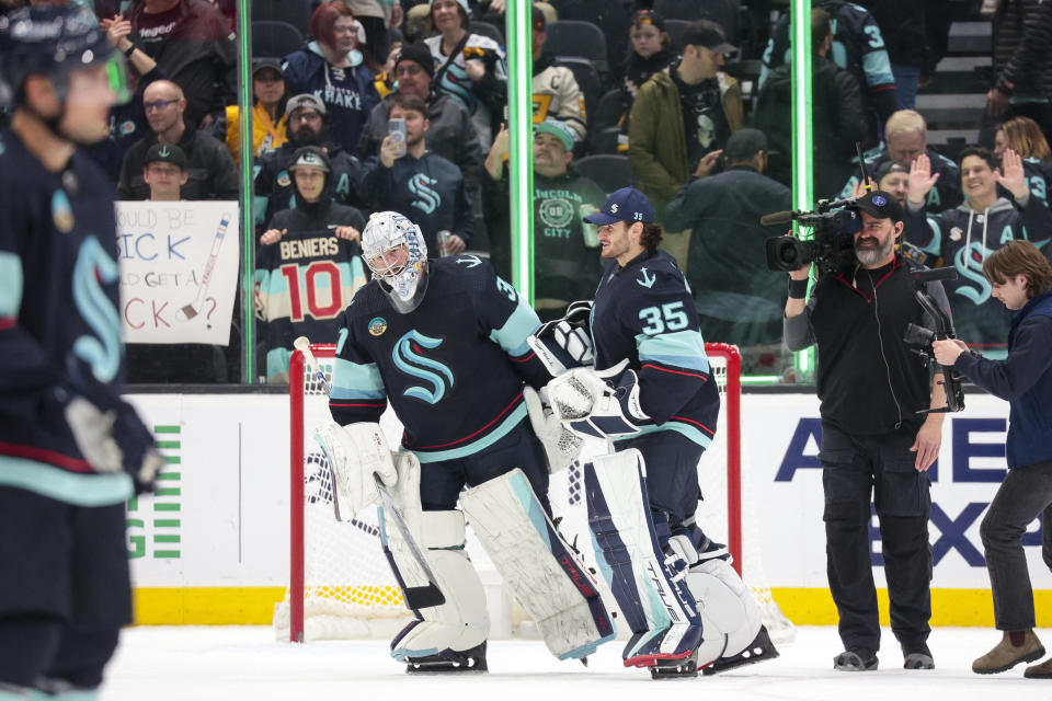 Seattle Kraken starting Philipp Grubauer, left, is congratulated by goaltender Joey Daccord (35) after shutting out the Pittsburgh Penguins in an NHL hockey game Thursday, Feb. 29, 2024, in Seattle. (AP Photo/Jason Redmond)