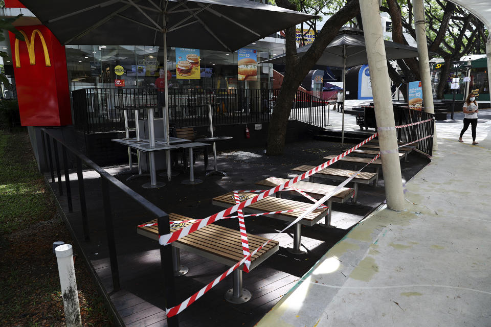 Seating areas at a McDonald's restaurant along the Orchard Road shopping belt are cordoned off in Singapore, Friday, April 10, 2020. The Singapore government put in place "circuit breaker" measures in the light of a sharp increase of COVID-19 cases in recent days. Under the measures which will last through May 4, people have to stay home and step out only for essential tasks, such as going to work if they are in essential services, buying food and groceries, or for a short bout of exercise. (AP Photo/Yong Teck Lim)