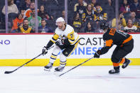 Pittsburgh Penguins' Jeff Carter, left, makes his move against Philadelphia Flyers' Travis Sanheim, right, during the first period of an NHL hockey game, Sunday, April 24, 2022, in Philadelphia. (AP Photo/Chris Szagola)
