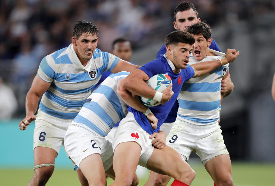 FILE - In this Saturday, Sept. 21, 2019 file photo, France's Romain Ntamack is tackled by Argentinian defenders during the Rugby World Cup Pool C game at Tokyo Stadium between France and Argentina in Tokyo, Japan. Flyhalf Ntamack, is the son of Emile Ntamack who played 46 times for France and is equal fifth on its all-time try scorers' list, is tipped to start Sunday's quarterfinal against Wales, 20 years after his father played the final. (AP Photo/Christophe Ena)