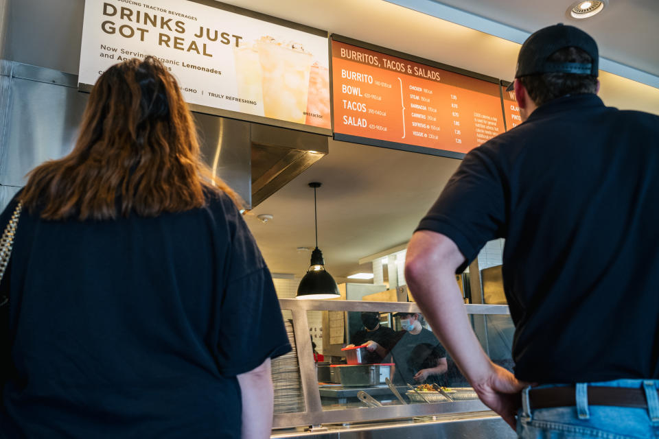 HOUSTON, TEXAS - JUNE 09: Customers view a menu at the Chipotle Mexican Grill on June 09, 2021 in Houston, Texas. Menu prices at the Chipotle Mexican Grill have risen by roughly 4% to cover the costs of raising its' minimum wage to $15 an hour for employees. The restaurant industry has been boosting wages in the hopes of attracting workers during a labor crunch. (Photo by Brandon Bell/Getty Images)