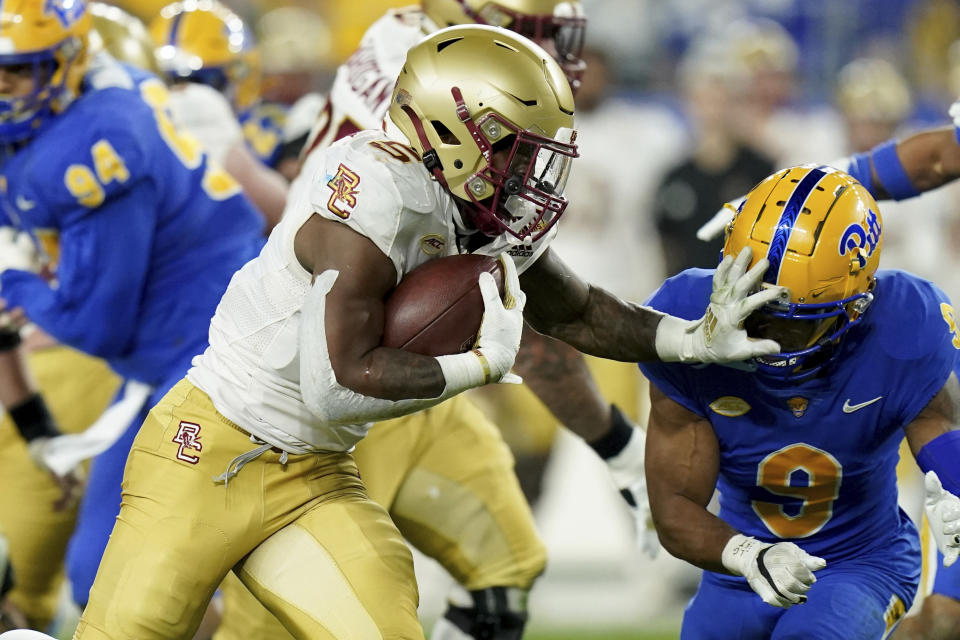 Boston College running back Kye Robichaux (5) carries past Pittsburgh defensive back A.J. Woods (9) during the first half of an NCAA college football game, Thursday, Nov. 16, 2023, in Pittsburgh. (AP Photo/Matt Freed)