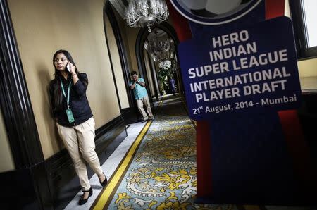 Reporters speak on their phones after attending a news conference during the international player draft for the Indian Super League in Mumbai August 21, 2014. REUTERS/Danish Siddiqui