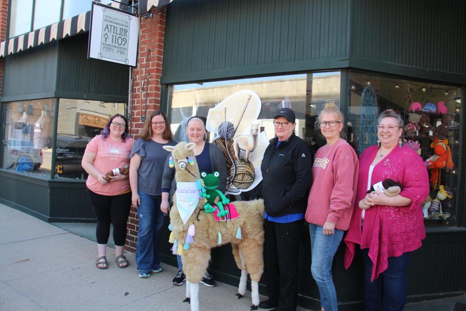 Fiber Festival of Perry organizers and artists pose for a photo with Alpacacino outside Atelier at 1109. From left, Savannah Scheufler, Carrie Cavanaugh, Ashley Anderson, Jenny Eklund, Shari Janssen and Shawna Meyer.