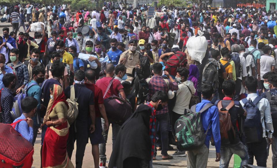 People wearing masks as a precaution against the coronavirus stand in queues to board trains at Lokmanya Tilak Terminus in Mumbai, India, Wednesday, April 14, 2021. Migrant workers are swarming rail stations in India's financial capital Mumbai to go to their home villages as virus-control measures dry up work in the hard-hit region. The government of Maharashtra state imposed lockdown-like curbs on Wednesday for 15 days to check the spread of the virus. It closed most industries, businesses and public places and limited the movement of people, but didn’t stop the bus, train and air services. An exodus ensued, with panicked day laborers hauling backpacks onto overcrowded trains leaving Mumbai, travel that raises fears of infections spreading in rural areas. (AP Photo/Rafiq Maqbool)