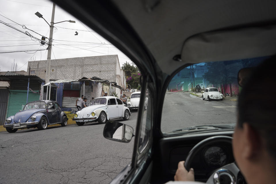 La taxista Janette Navarro conduce su Volkswagen Beetle de 1996 por una colina empinada en el vecindario Cuautepec, en Ciudad de México, el viernes 21 de junio de 2024. Navarro comenzó a manejar vochos para trabajar hace ocho años como una forma de mantener a sus tres hijos y pagarles los estudios.. (AP Foto/Aurea Del Rosario)