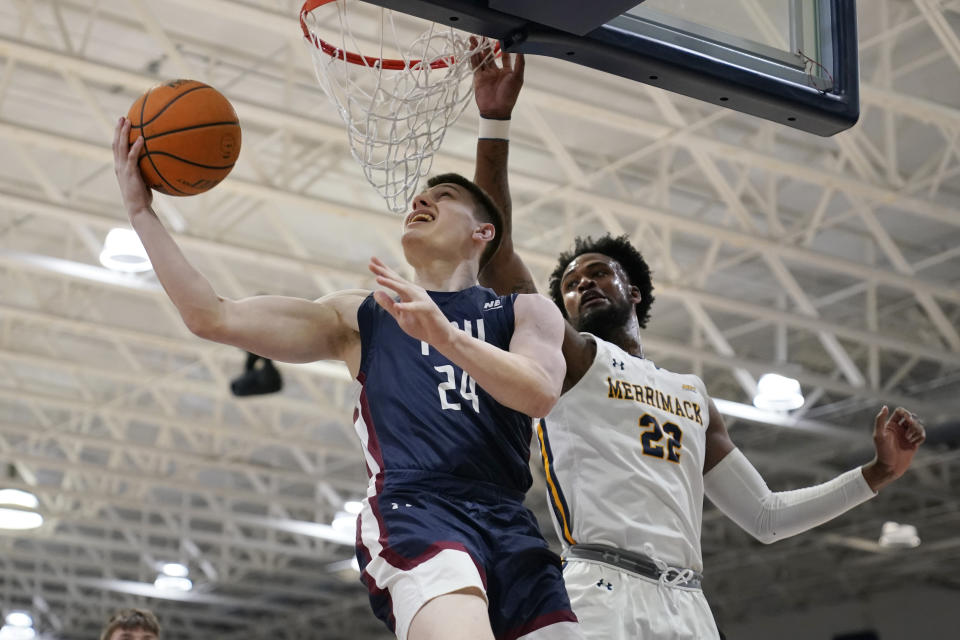 Fairleigh Dickinson guard Brayden Reynolds (24) drives past Merrimack forward Jordan Minor (22) during the first half of Northeast Conference men's NCAA college basketball championship game, Tuesday, March 7, 2023, in North Andover, Mass. (AP Photo/Charles Krupa)