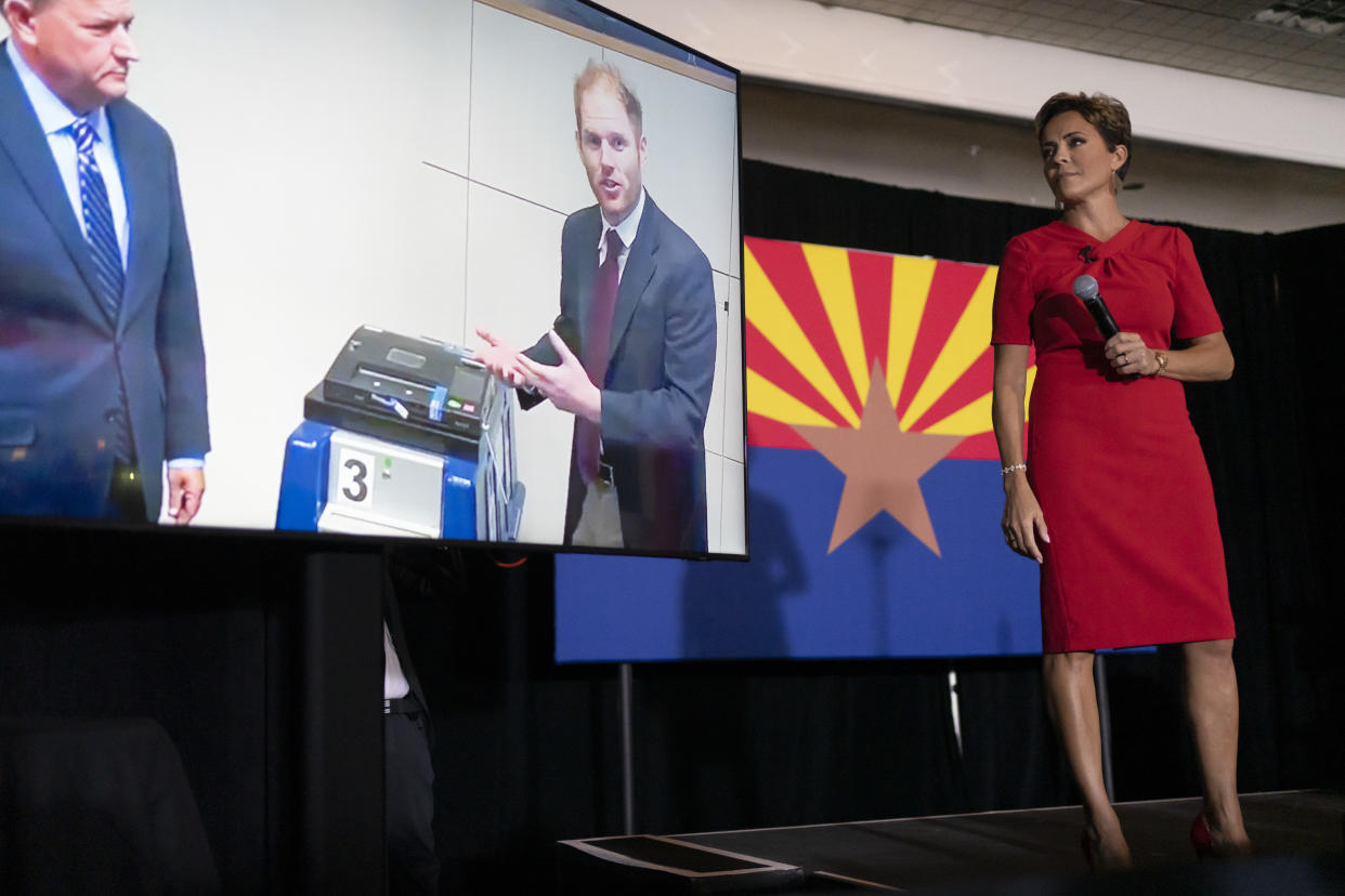 Kari Lake, right, shows a photo of Stephen Richer, Maricopa County Recorder, during a rally in Scottsdale, Ariz., on Jan. 29, 2023. (Rebecca Noble/The New York Times)