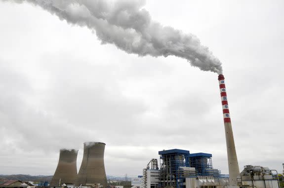 Smoke and steam are discharged from a chimney and cooling towers at a coal-fired power plant in Tongren city, China on March 8, 2016.