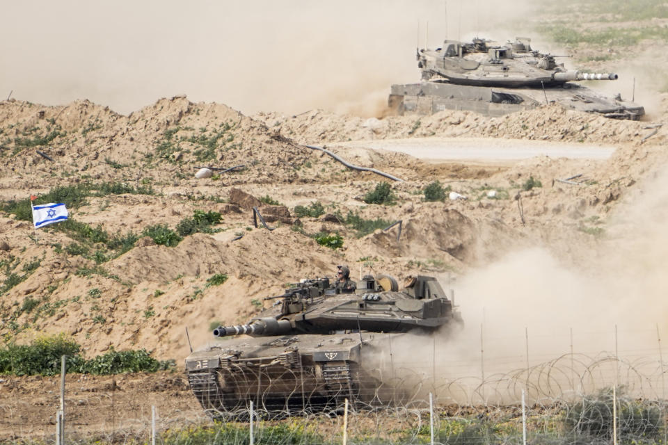 Israeli soldiers drive tanks on inside Gaza Strip, as seen from southern Israel, Tuesday, Feb. 13, 2024. The army is battling Palestinian militants across Gaza in the war ignited by Hamas' Oct. 7 attack into Israel. (AP Photo/Ariel Schalit)