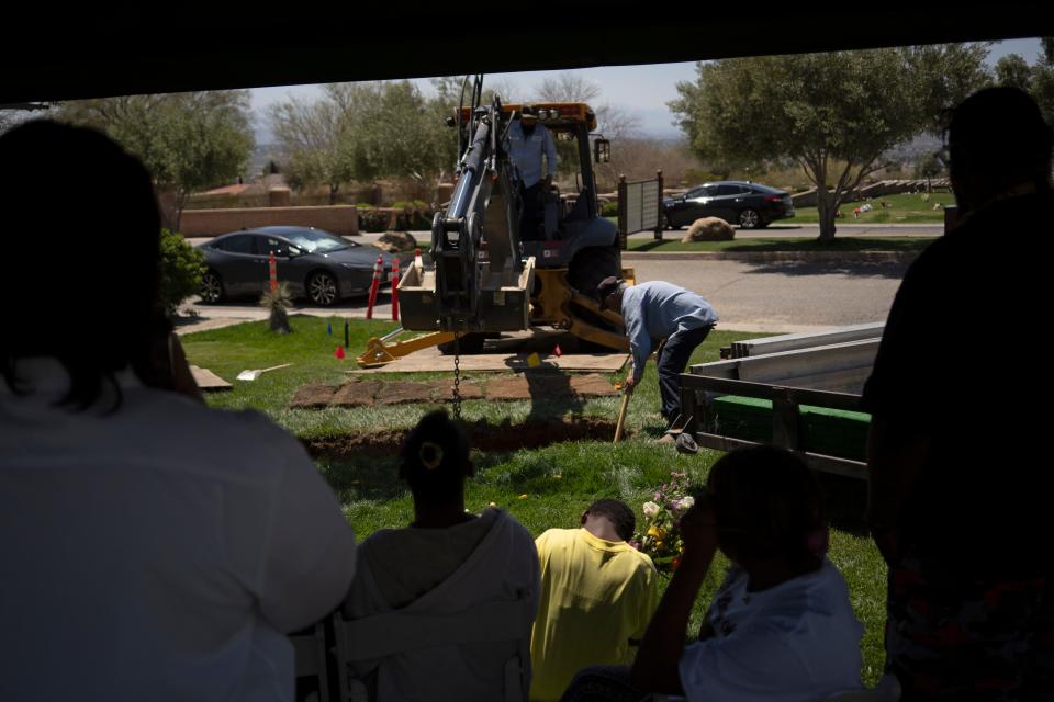 Anaya Avery, center-left, and Amaya Avery, center-right, sit along with Ryan Gainer’s family as they watch the final burial on Saturday, April 20, 2024 at Sunset Hills Memorial Park in Apple Valley.