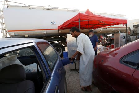 Man fills a car with fuel from Brega in Tripoli