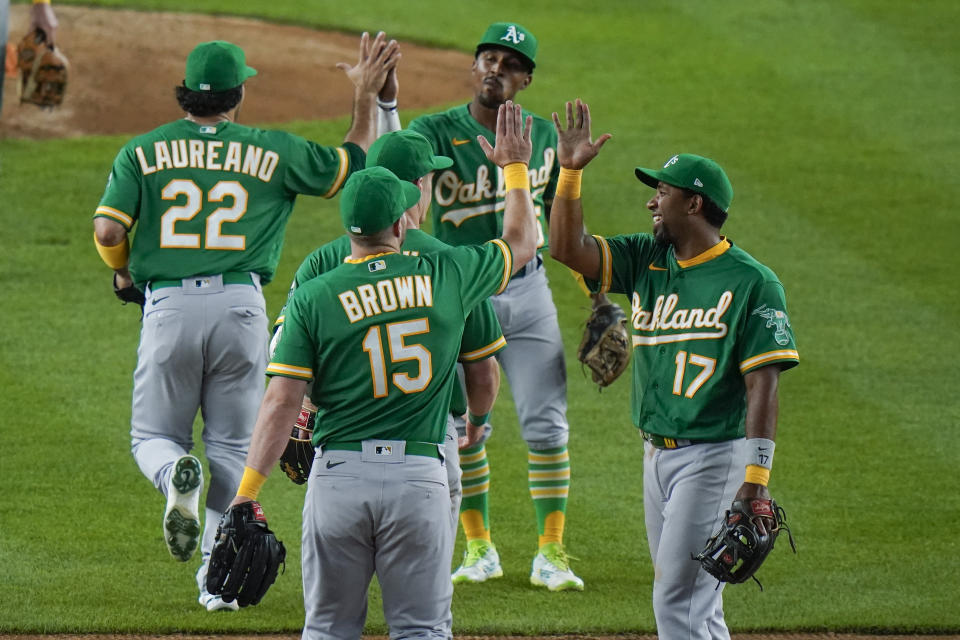 Oakland Athletics' Ramon Laureano (22), Seth Brown (15), Elvis Andrus (17) and Tony Kemp celebrate after the team's baseball game against the New York Yankees on Friday, June 18, 2021, in New York. The Athletics won 5-3. (AP Photo/Frank Franklin II)