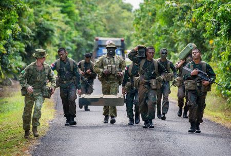 FILE PHOTO: Australian Army soldiers Major General Stuart Smith (L) and Sergeant Francis Jakis (C) run with Indonesian Army soldiers during the Junior Officer Combat Instructor Training course conducted by the Australian Army's Combat Training Centre in Tully, Australia, October 10, 2014. Australian Defence Force/Handout via REUTERS/File Photo