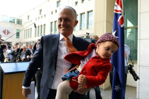 Outgoing Australian Prime Minister Malcolm Turnbull leaves a press conference with his granddaughter Alice after giving his final press in Canberra on Friday