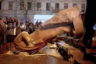 People surround a statue of Soviet state founder Vladimir Lenin, which was toppled by protesters during a rally organized by supporters of EU integration in Kiev, December 8, 2013. Crowds toppled a statue of Soviet state founder Vladimir Lenin in the Ukrainian capital and attacked it with hammers on Sunday in the latest mass protests against President Viktor Yanukovich and his plans for closer ties with Russia. REUTERS/Maks Levin (UKRAINE - Tags: POLITICS CIVIL UNREST)