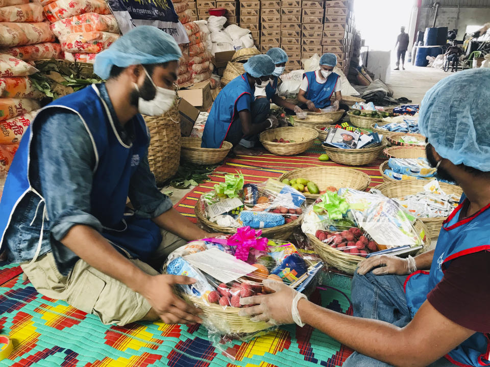 Members of Bidyanondo Foundation pack packages for distribution to COVID-19 patients in Dhaka, Bangladesh, Saturday, June 6, 2020. The Bangladeshi group of volunteers is providing COVID-19 patients with fruit baskets and “get well soon” cards to keep their spirits up amid reports that many patients are being ostracized by their families and neighbors. The group stepped in after disturbing news reports that a woman has been abandoned in a forest by her family after she developed coronavirus symptoms. (AP Photo/Al-emrun Garjon)