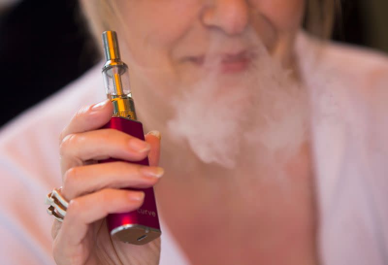 A woman smokes an electronic cigarette in London