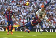 Barcelona's Gerard Pique (C) fights for the ball against Real Madrid's Karim Benzema (R) as Barcelona's Daniel Alves looks on during their Spanish first division "Clasico" soccer match at the Santiago Bernabeu stadium in Madrid October 25, 2014. REUTERS/Juan Medina (SPAIN - Tags: SOCCER SPORT)