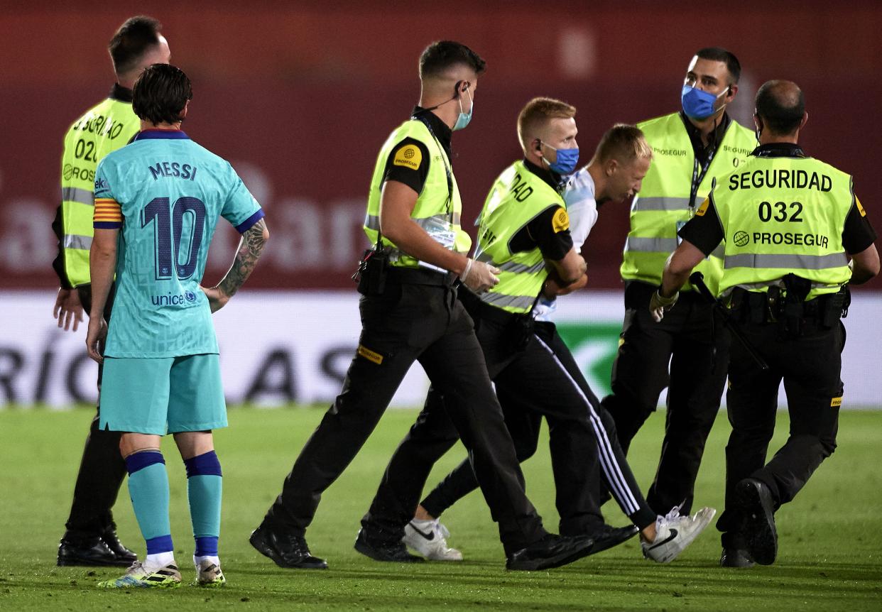 MALLORCA, SPAIN - JUNE 13: A pitch invader is escorted off the pitch during the Liga match between RCD Mallorca and FC Barcelona at Iberostar Estadi on June 13, 2020 in Mallorca, Spain. (Photo by Quality Sport Images/Getty Images)