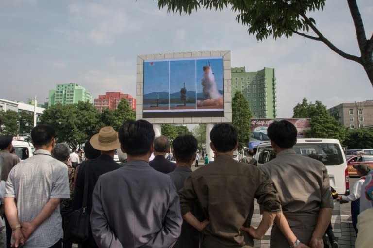 People watch a screen showing coverage of the Pukguksong-2 missile launch, in central Pyongyang on May 22, 2017