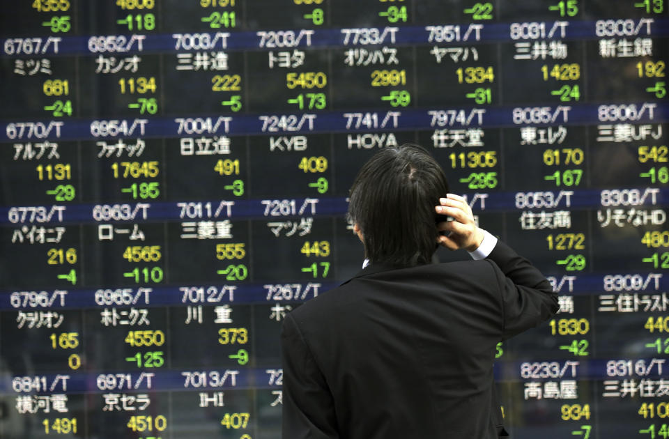 A man looks at an electronic stock board of a securities firm in Tokyo, Wednesday, April 9, 2014. Asian stocks were mostly higher Wednesday, except for Japan where the main index tumbled on a rise in the yen. (AP Photo/Eugene Hoshiko)