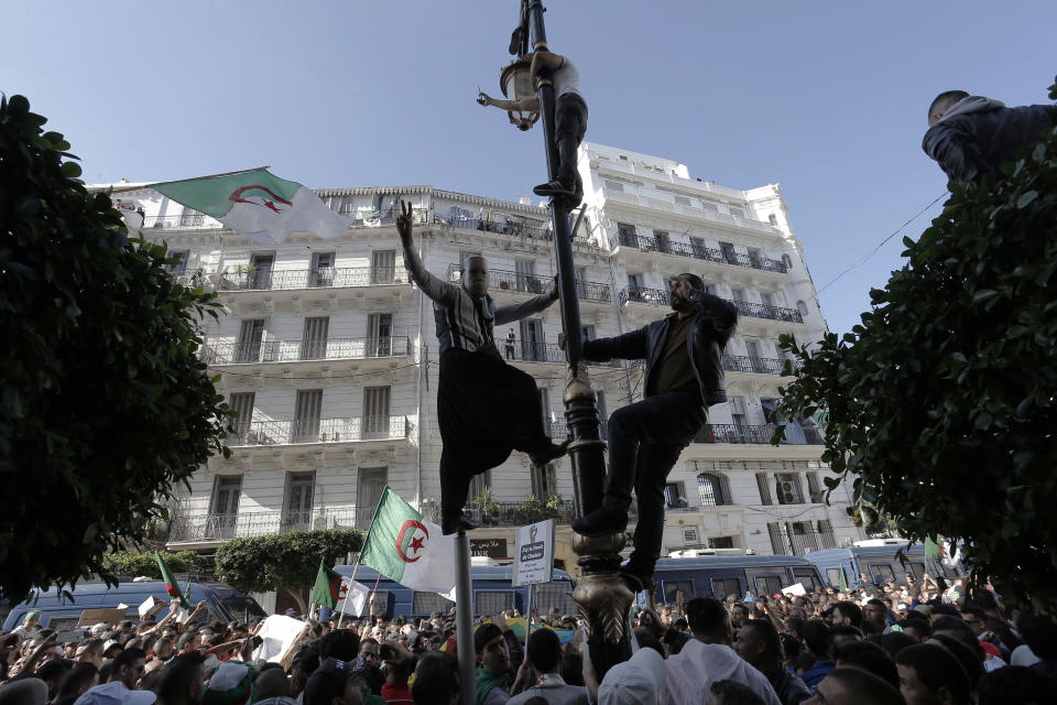 Algerian demonstrators take to the streets in the capital Algiers to protest against the government, in Algeria, Friday, Nov. 1, 2019. Police struggled Friday to contain thousands of Algerian demonstrators surging through the streets of the capital to protest next month's presidential election and celebrate 65 years since Algeria's war for independence from France. (AP Photo/Toufik Doudou)