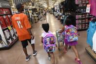 <p>Young Alize Keys, right, and Ke’yondriah Hugely, middle, both 6, lead Denver Broncos wide receiver Jordan Norwood, #11, through the aisles as they shop for school supplies at King Soopers Marketplace on July 25, 2016 in Parker, Colorado. </p>