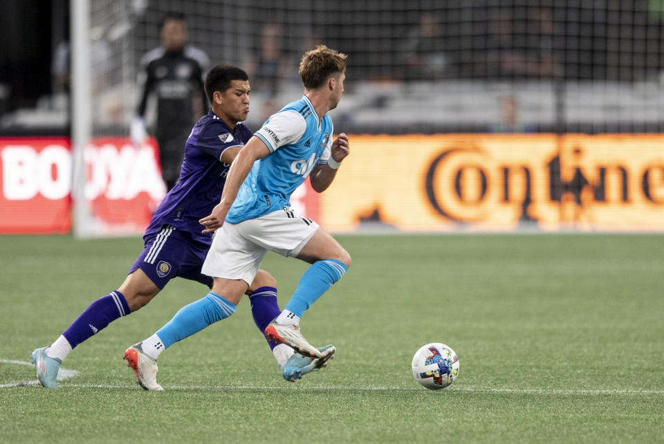 Charlotte FC midfielder Quinn McNeill and Orlando City midfielder César Araújo fight for the ball during the first half of an MLS soccer match, Sunday, Aug. 21, 2022, in Charlotte, N.C. (AP Photo/Matt Kelley)