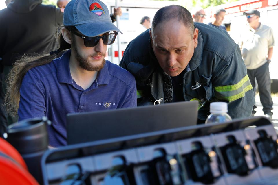 Telops field application engineer, Joe Carrokc, goes over the explosion data with New Bedford Firefighter Travis Rebello, operations officer for the State Hazmat Team, at a lithium battery fire demonstration hosted by New Bedford Fire Department.