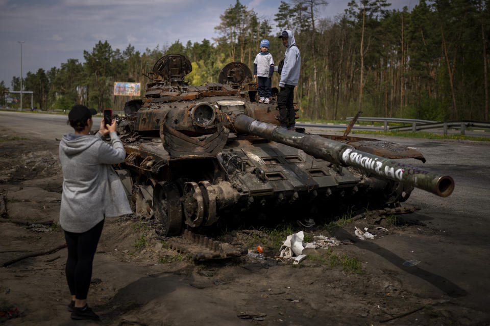 FILE - Maksym, 3, is photographed with his brother, Dmytro, 16, on top of a destroyed Russian tank, on the outskirts of Kyiv, Ukraine, May 8, 2022. Three months after it invaded Ukraine hoping to overtake the country in a blitz, Russia has bogged down in what increasingly looks like a war of attrition with no end in sight. (AP Photo/Emilio Morenatti, File)